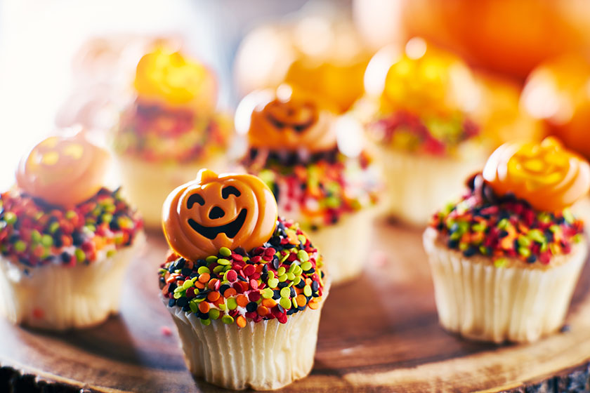 Мъфини за Хелоуин с украса от шарени топчета, тиква и шоколадова заливка
