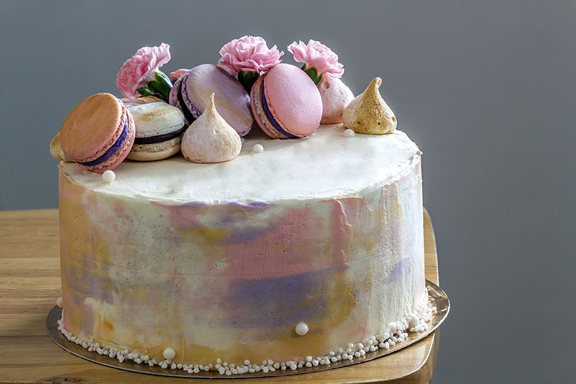 Цветна празнична торта в пастелни тонове с декорация от френски макарони